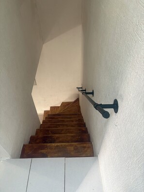 A staircase with wooden steps and a handrail, leading upwards. - Small house with a natural cenote in Playa del Carmen (Playa del Carmen)