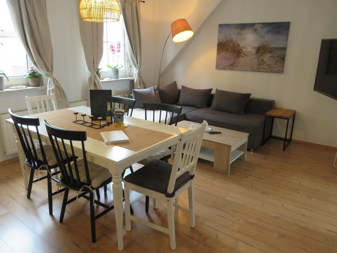 Un salon chaleureux avec une table à manger, des chaises, un canapé et une table basse.