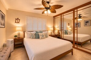A bedroom with a large bed, bedside lamps, a ceiling fan, and a full-length mirror. - Ocean View Retreat - Walk to Kamaole Beach - Spacious Lanai (Kihei)