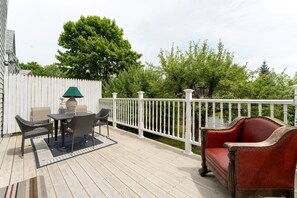 A wooden deck with outdoor furniture, a white fence, and a tree. - Northeast Harbor Hideaway | Walk to the waterfront (Mount Desert)