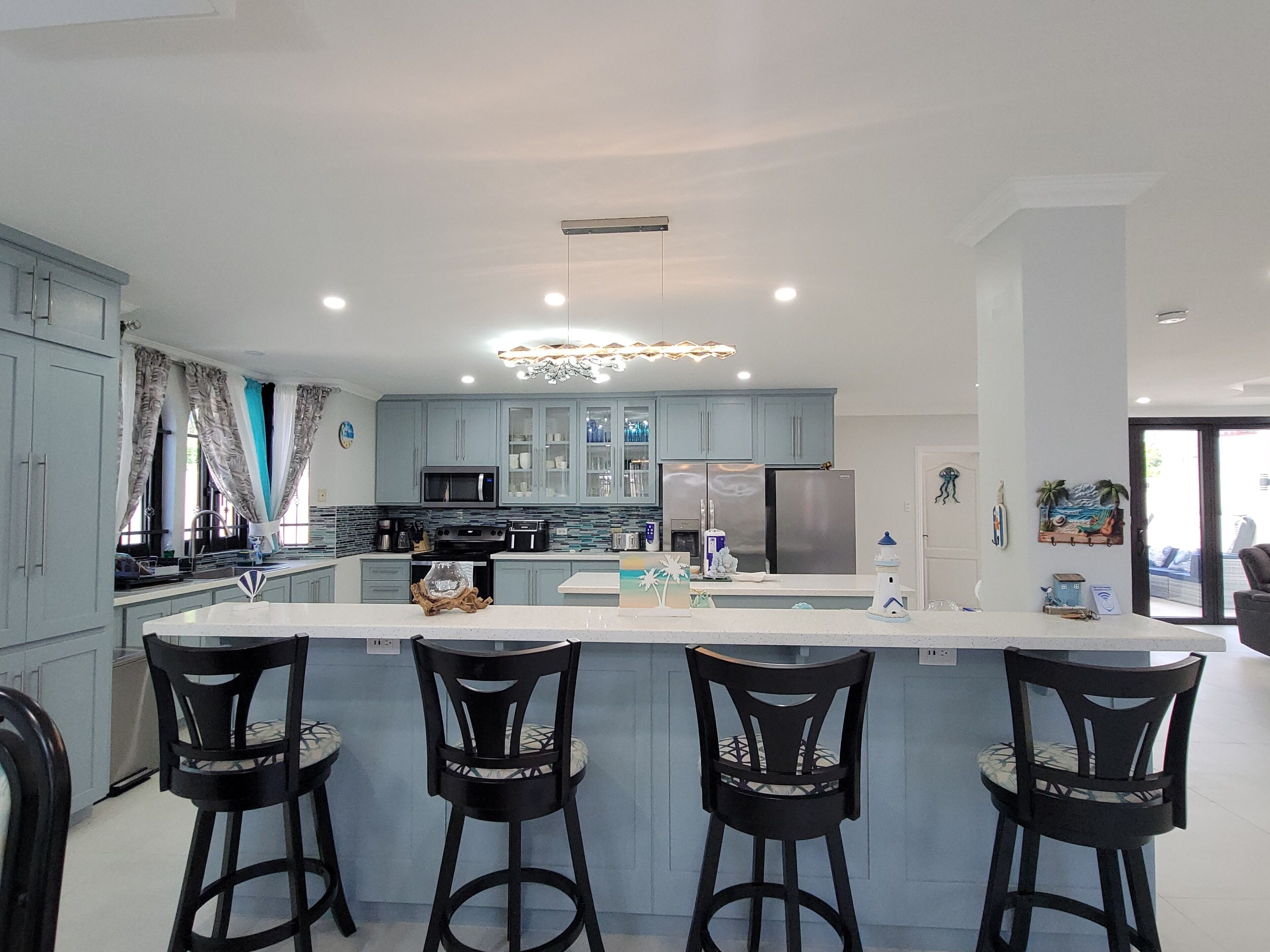 Une cuisine moderne dotée d’un îlot central, de tabourets de bar et d’un coin repas.