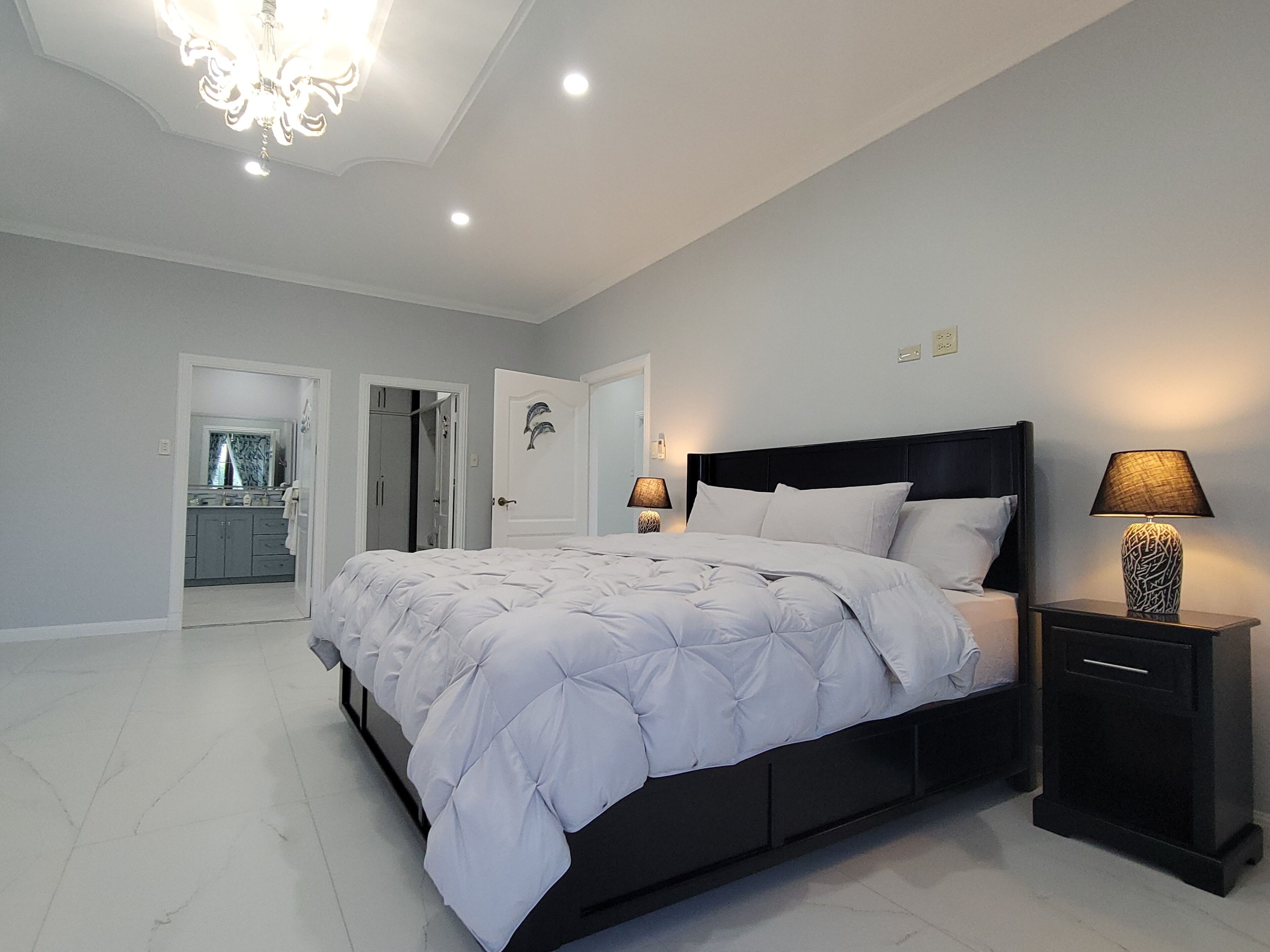 Une chambre à coucher avec un lit, des tables de chevet et un lustre.