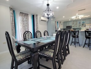 A dining area with a rectangular table, six chairs, and a chandelier.