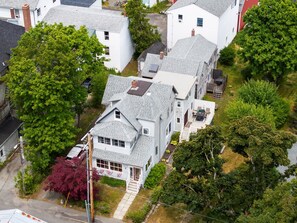 Una zona residencial con varias casas, incluyendo una de dos plantas con porche delantero y garaje.