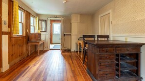 A wooden interior with a dining table, chairs, and a kitchen area. - Spacious Harbor Retreat | Easy Access to Downtown (Mount Desert)