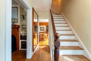 A staircase with wooden steps and a handrail, leading to a dining area with wooden chairs and a table. - Charming Home Apt - Walk to Acadia & the Harbor (Mount Desert)
