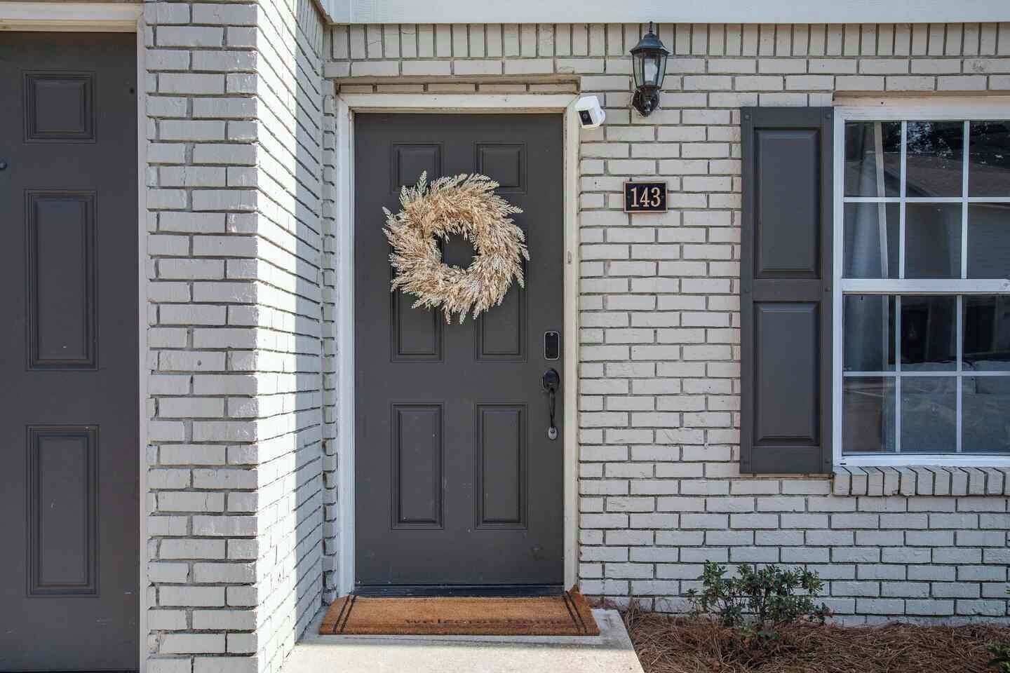 A house with a dark front door, a wreath, and a mailbox.