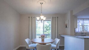 A dining area with a round table, four chairs, a chandelier, and a view of the outdoors through a window. - The Redbird, Walk to Square, VelvetDitchVillas (Oxford)