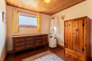 A room with a wooden wardrobe, a window with yellow curtains, a radiator, and a patterned rug. - Full Lovely Home Walking Distance to Town & Harbor (Mount Desert)