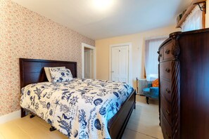 A bedroom with a bed, a dresser, a door, and a window with curtains. - Full Lovely Home Walking Distance to Town & Harbor (Mount Desert)