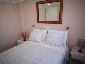 A bedroom with a bed, two bedside tables, a mirror, and a door. - Feather House FH Wine Cellar (São Bartolomeu de Galegos)