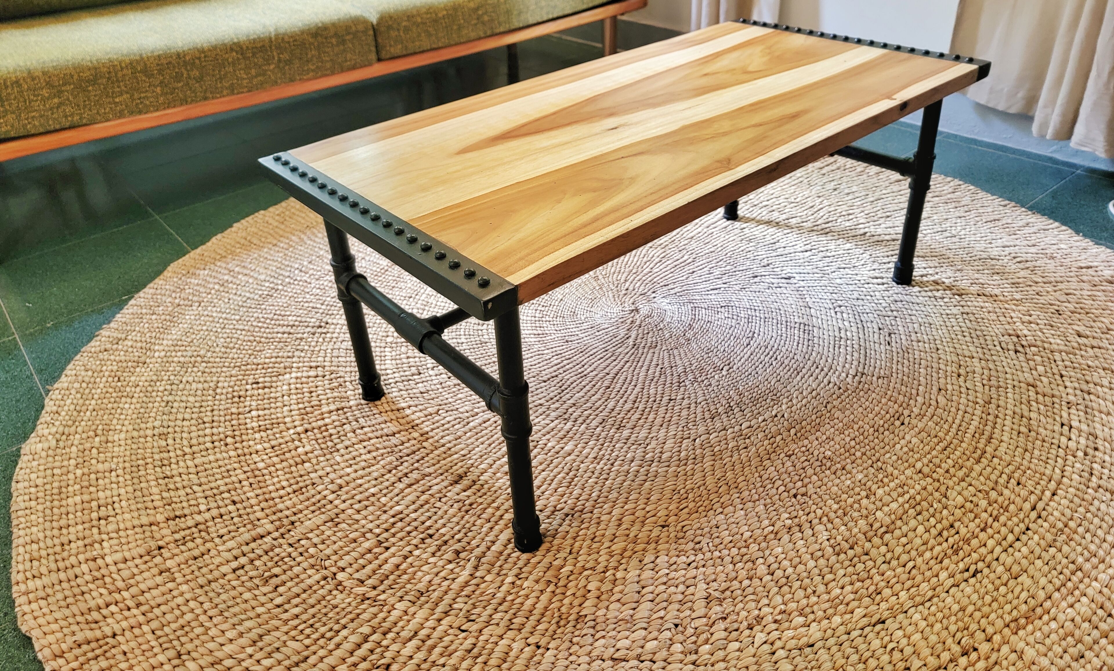 A wooden table with metal legs on a woven rug.