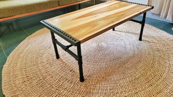 A wooden table with metal legs on a woven rug.