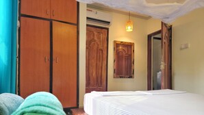 Ein Schlafzimmer mit einem Bett, einem Holzschrank und einem an der Wand befestigten Schrank.