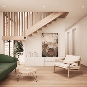 A modern living room with a staircase, a green sofa, a round coffee table, and a white armchair. - Summer 2027 - Brand New Luxury Vacation Rental in Lewes, Delaware, 5 bedrooms (Lewes)