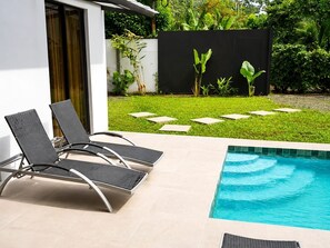 A modern outdoor pool area with lounge chairs and a clear blue pool. - Villa Isora, New Villa with Private Pool, Playa Negra, Puerto Viejo. (Puerto Viejo de Talamanca)