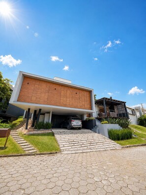 A modern house with a flat roof, a garage, and a paved driveway.