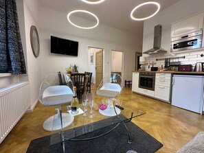 Eine moderne Küche mit weißen Schränken, einem Edelstahlbackofen und einer eingebauten Mikrowelle.