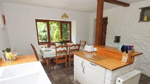 A kitchen with a wooden countertop, a white sink, and a stone wall. - Penrhiwoli Barn (Llangammarch Wells)