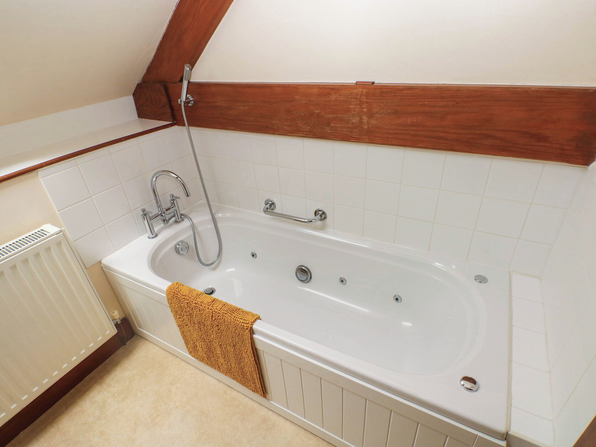 A bathroom with a bathtub, a shower, and a towel.