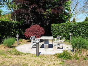 Un tavolo rotondo con sedie in un giardino.