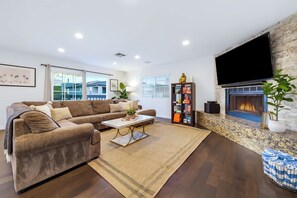 Een moderne woonkamer met een bank, salontafel en een open haard.