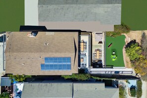 A rooftop with solar panels, a small garden, and a parking area. - Pacific Grand - Dual Living Near Mission Bay (San Diego)