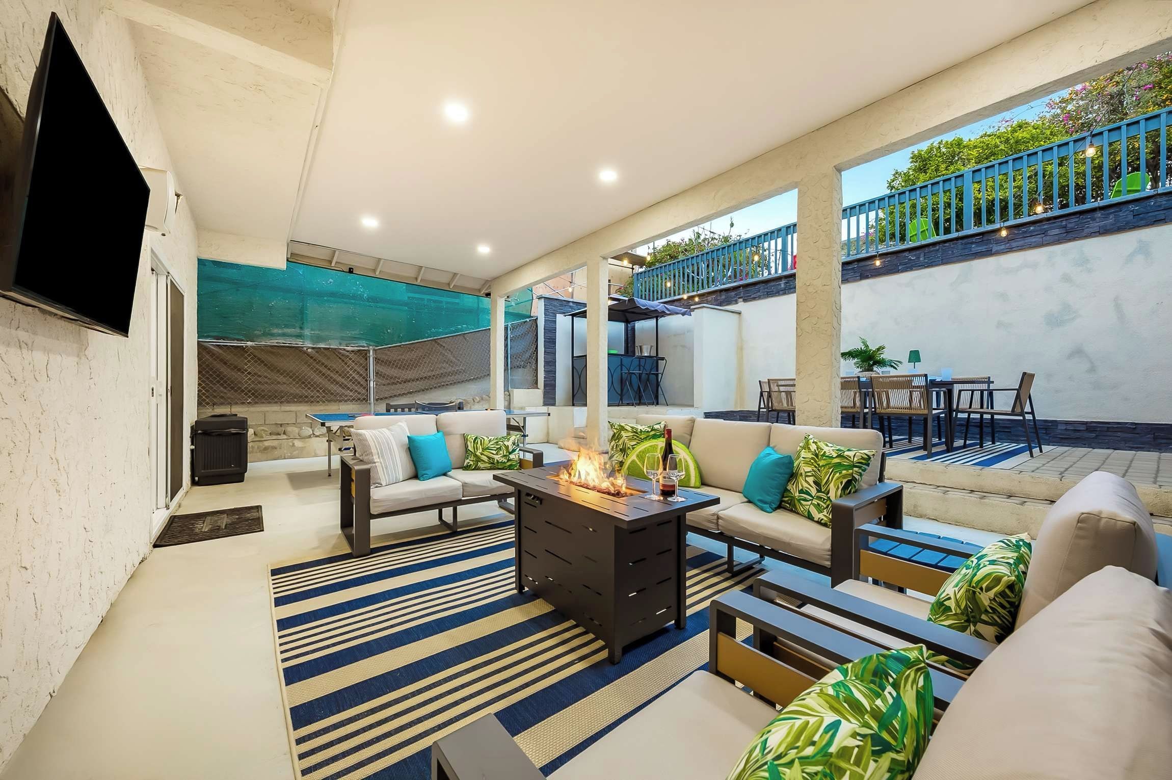 A modern living room with a flat-screen TV, a fireplace, and a balcony with outdoor seating.
