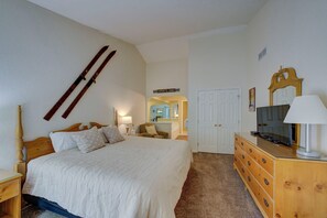 A bedroom with a bed, dresser, TV, and a mirror. - Dreams and Streams at Pinebrook- Your Perfect Northern Michigan Escape! (Bellaire)