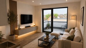 Een moderne woonkamer met een flatscreen televisie, een bank, een salontafel en een balkon met uitzicht.