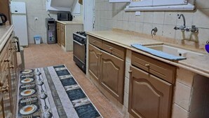 A kitchen with a refrigerator, microwave, stove, sink, and cabinets. - Villa Cranzy: 3BR with private pool, bianki, AL agami, Alexandria ,Egypt (Alexandria Governorate)