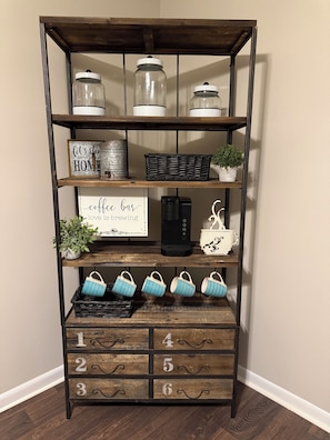 A wooden shelf with jars, a coffee sign, a coffee maker, and numbered drawers. - 2-bedroom house in pleasant Rolla with cool AC for relaxing stays (Rolla)