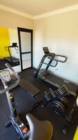 A gym with exercise equipment including a treadmill, stationary bike, and weights.
