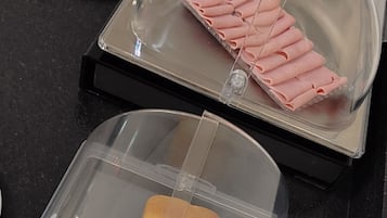 Eine Speisenauslage mit Brot und Schinken.