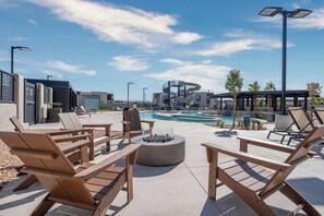 A poolside area with lounge chairs, a fire pit, and a water slide structure. - 4 bedroom accommodation in Washington (Washington)