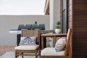 An outdoor seating area with two wooden chairs, a small table, and a grill. - 4 bedroom accommodation in Washington (Washington)