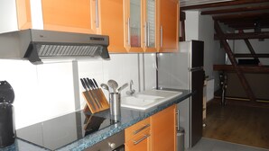 A kitchen with a stainless steel range hood, a sink, and a countertop with a knife block.