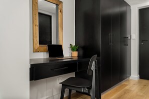 A modern room with a black desk, a laptop, a potted plant, and a chair. - Skyline Tokyo Studio w/ Table Mountain Views & Rooftop Pool and Lounge (Cape Town)