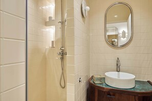 Ein Badezimmer mit Dusche, Waschbecken und Spiegel.