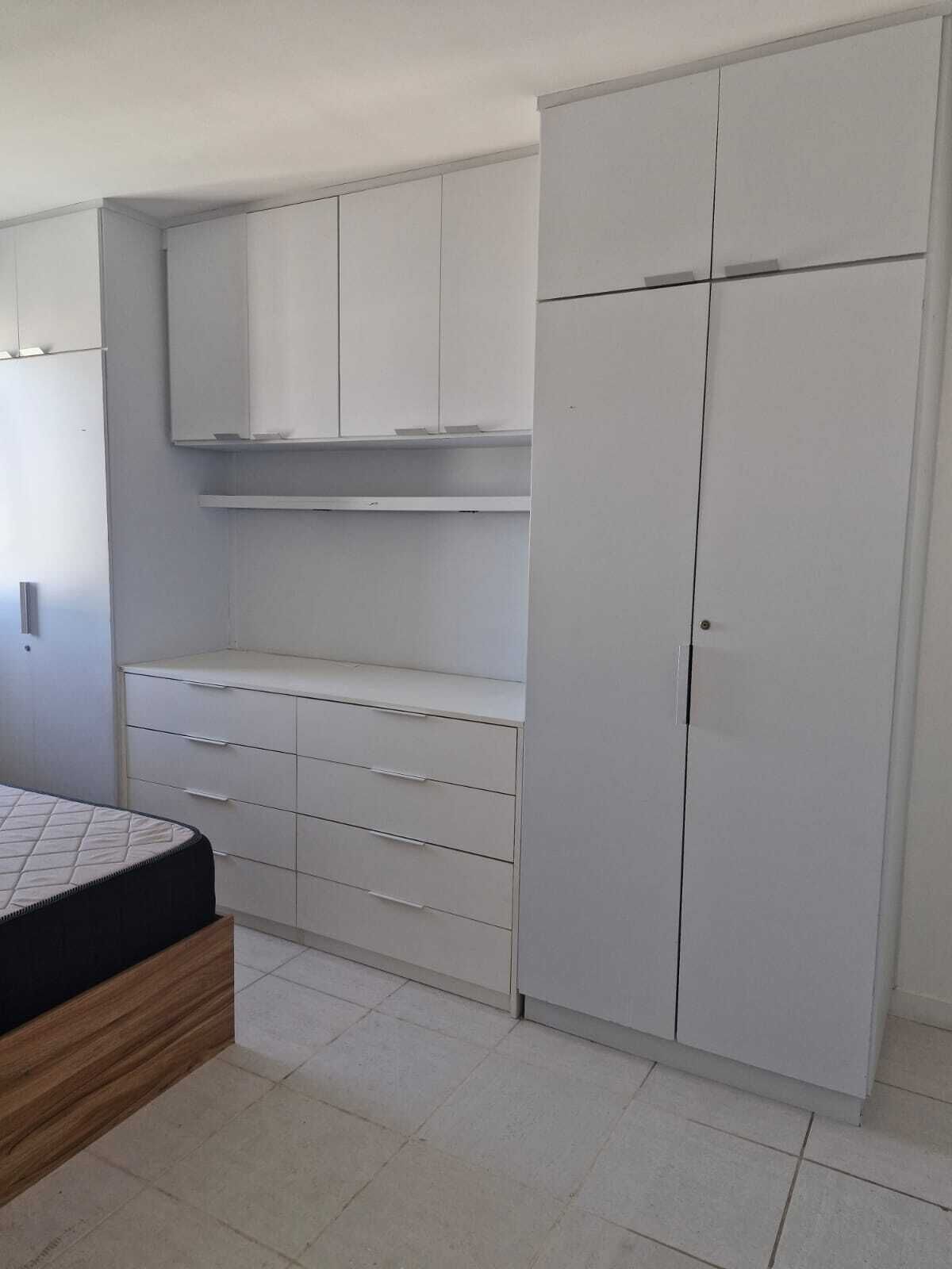 A bedroom with a bed, a dresser, and a wardrobe.