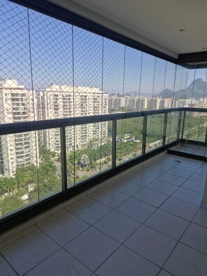 Un balcón con vistas a edificios altos y zonas verdes.