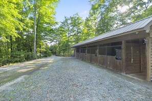 A gravel driveway leading to a wooden building with multiple stalls. - Leatherwood MNT | Pinnacle Pt w/ 4-Stall Barn (Ferguson)