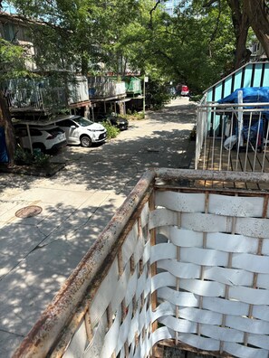A street view with parked cars, a metal fence, and trees. - Ideal place to get two floors at a great price (Toronto)