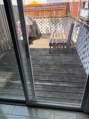 A wooden deck with a bench and a brick wall in the background. - Ideal place to get two floors at a great price (Toronto)