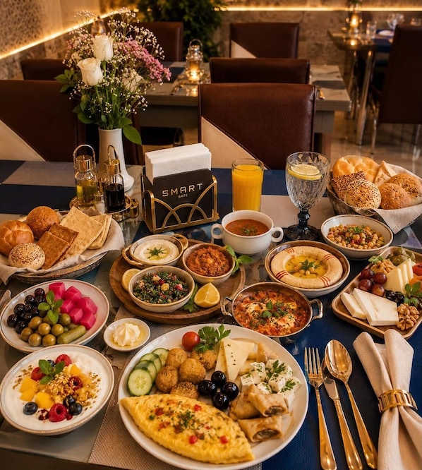 A breakfast buffet with a variety of dishes, including bread, dips, and a selection of fruits and vegetables.