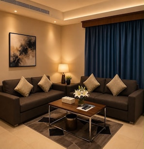 A modern living room with two sofas, a coffee table, a lamp, and a painting on the wall.