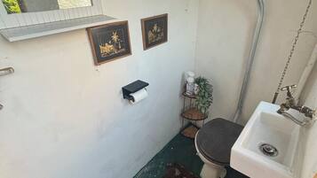 Un baño pequeño con inodoro, lavamanos y espejo.