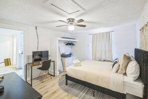 A bedroom with a bed, a desk, a chair, a television, a ceiling fan, and a wardrobe. - Cozy 1BR In Central Dallas Location Near FIFA WC (Dallas)