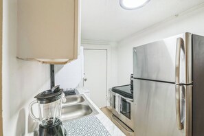 A compact kitchen with a stainless steel refrigerator, a built-in oven, and a sink. - Cozy 1BR In Central Dallas Location Near FIFA WC (Dallas)