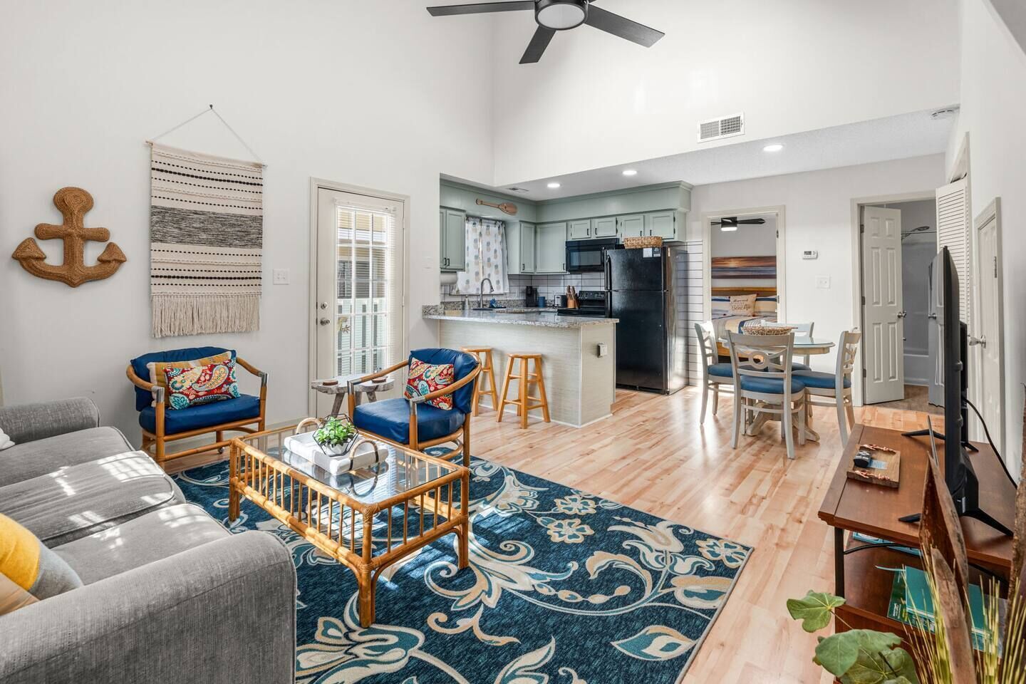 A modern living room with a sofa, chairs, a coffee table, and a patterned rug.